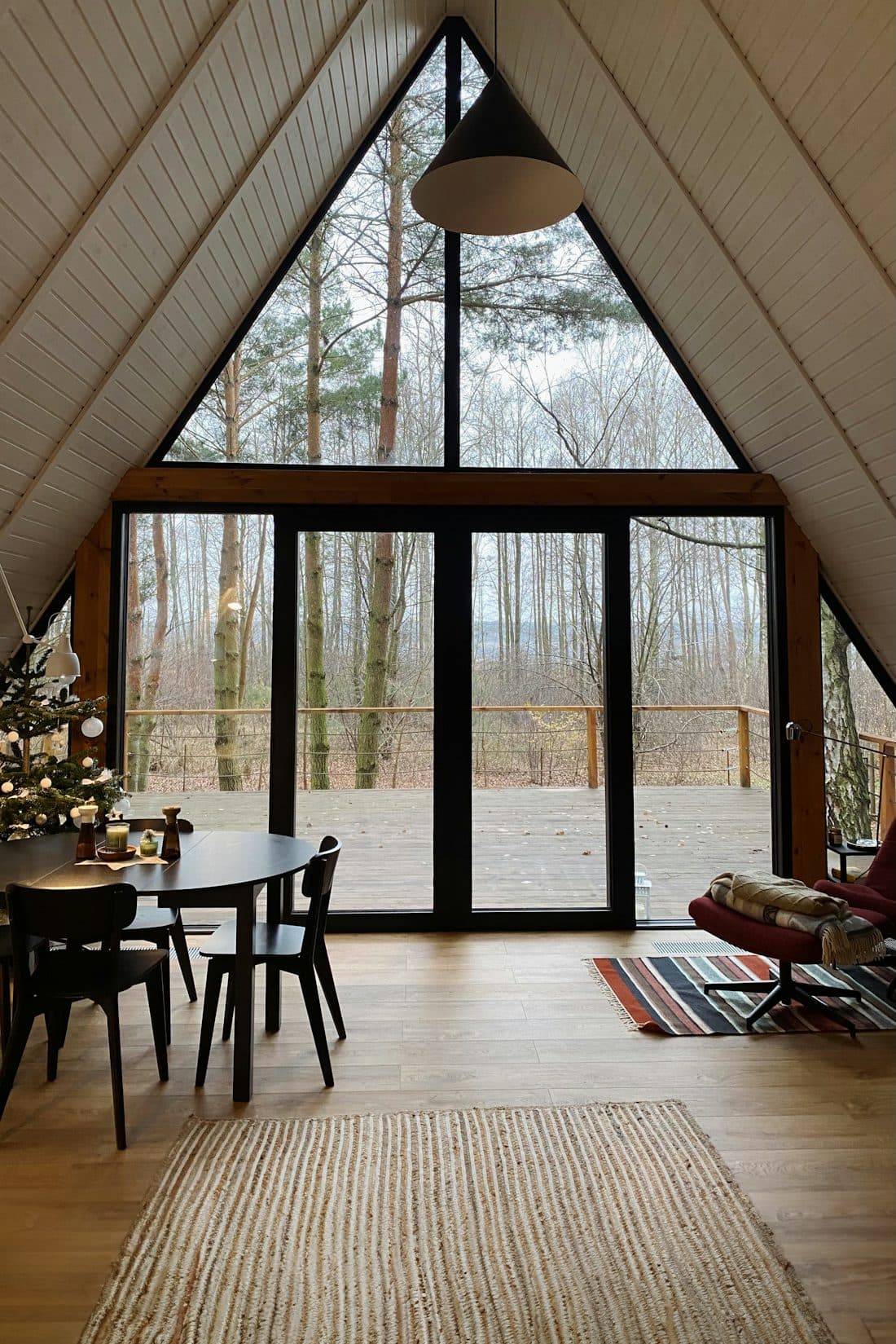 Heller Innenraum mit Holzdecke, Tisch und großem Fenster