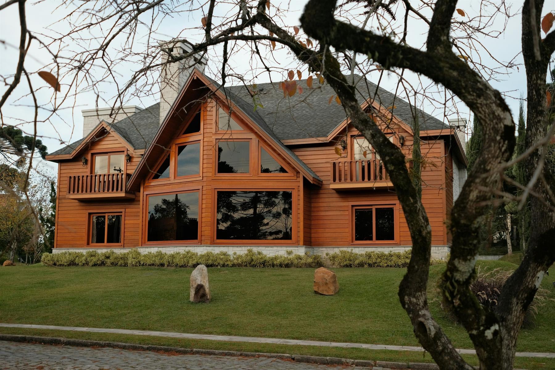 Große Holzvilla mit Giebeln, Balkonen und hohen Fensterflächen